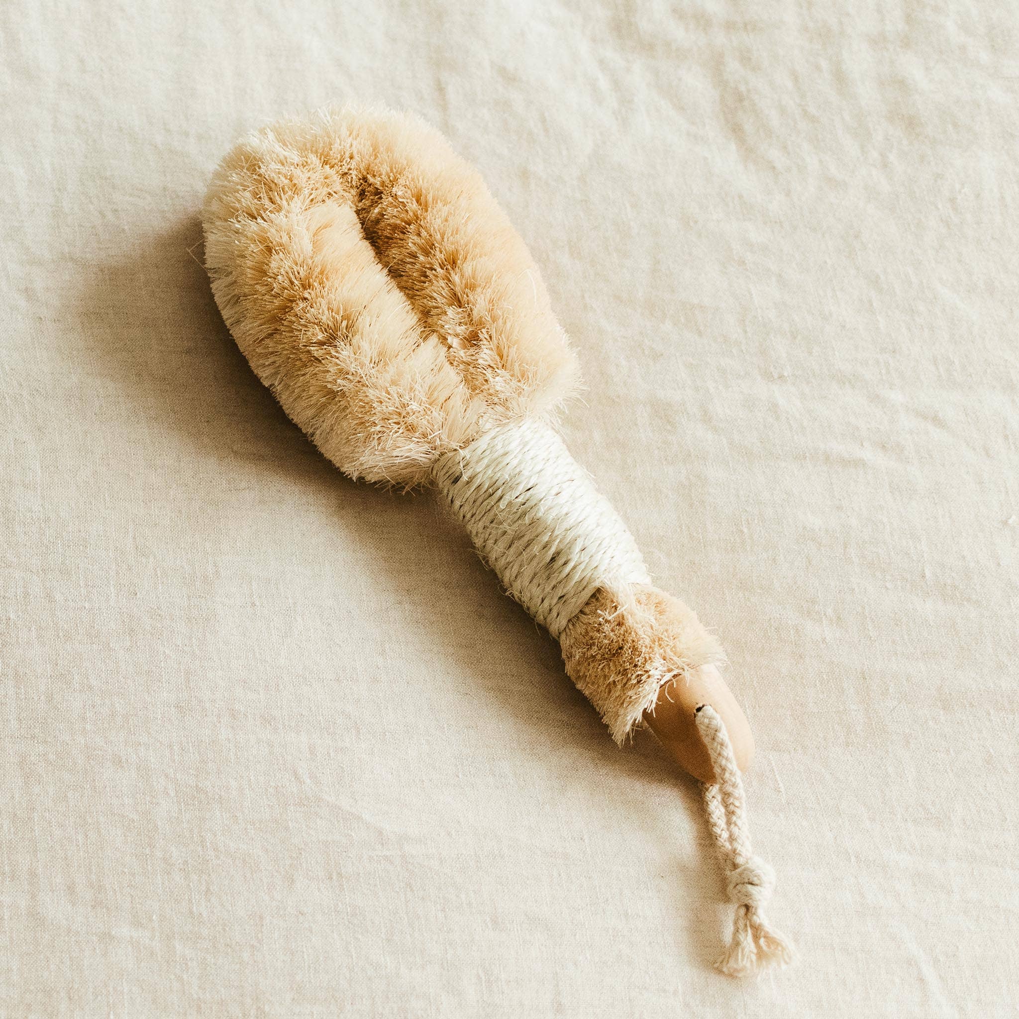 Exfoliating Body Brush in use on skin, stimulating circulation dry brush technique